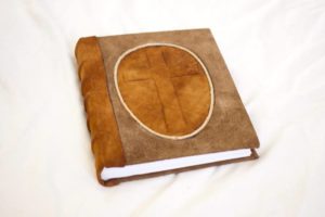A journal, two tone goatskins leather with raised cross.